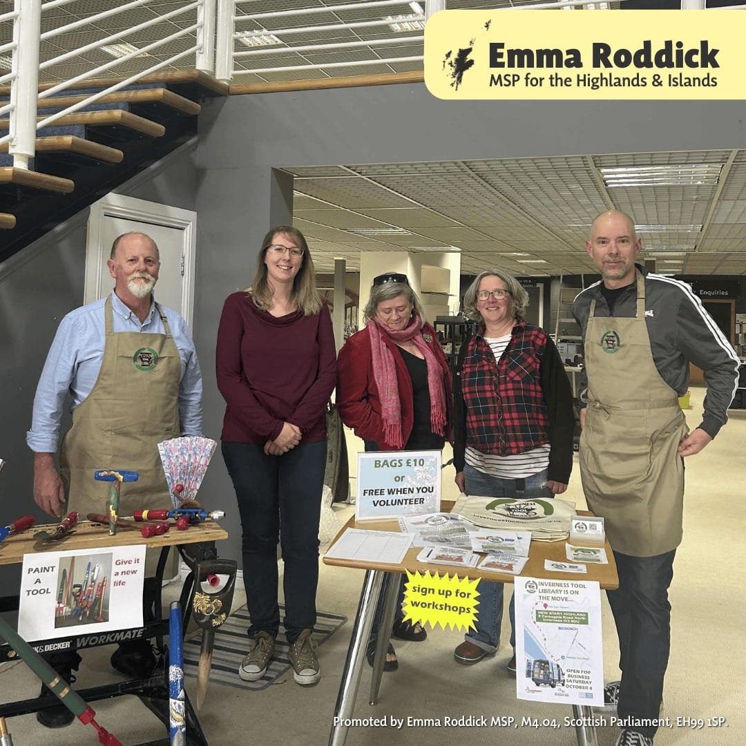 Emma Roddick MSP – Tool Library Emma smiling, wearing red jumper, standing with volunteers inside the Tool Library building